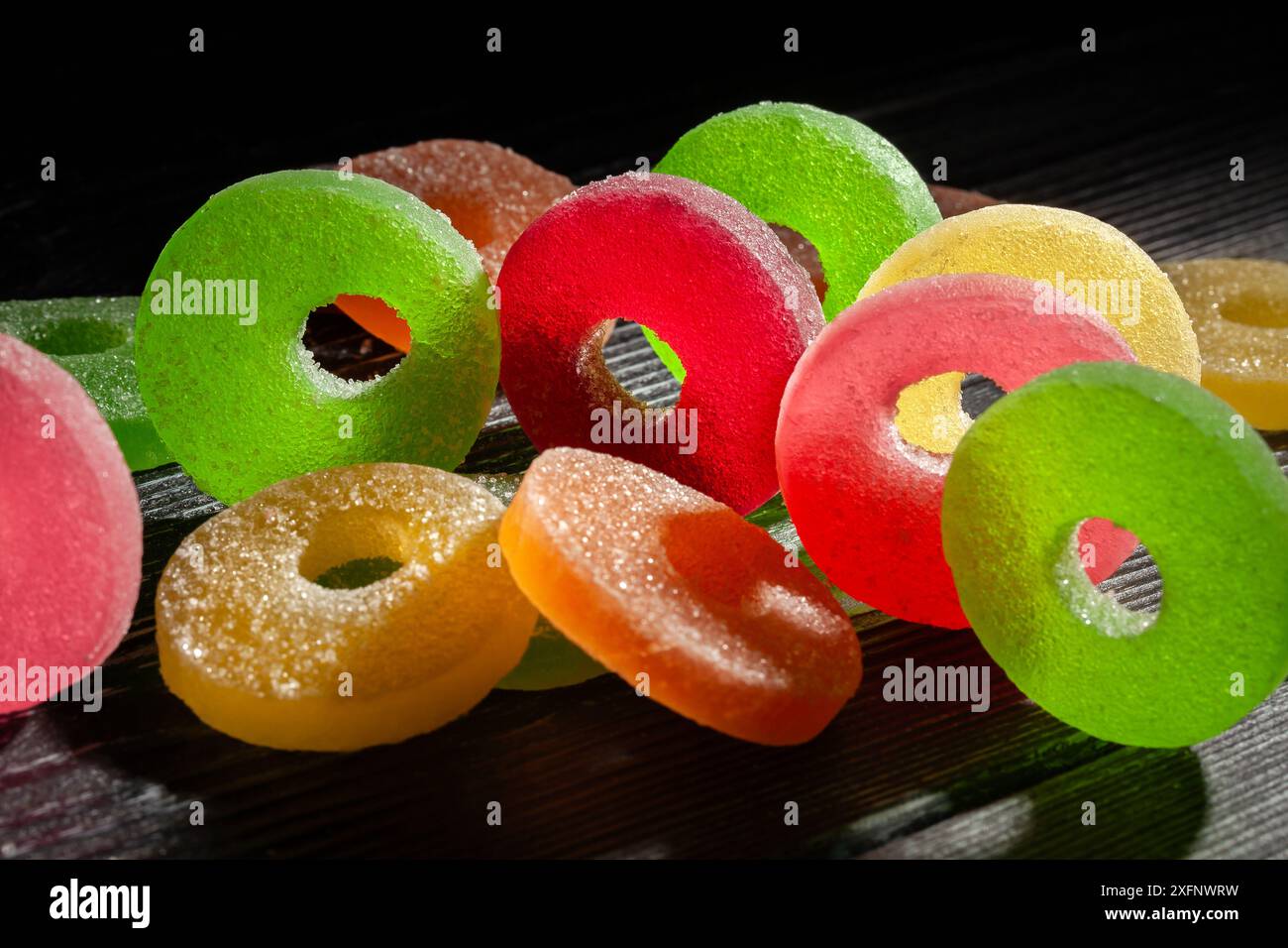 caramelle in gelatina su sfondo in legno nero Foto Stock