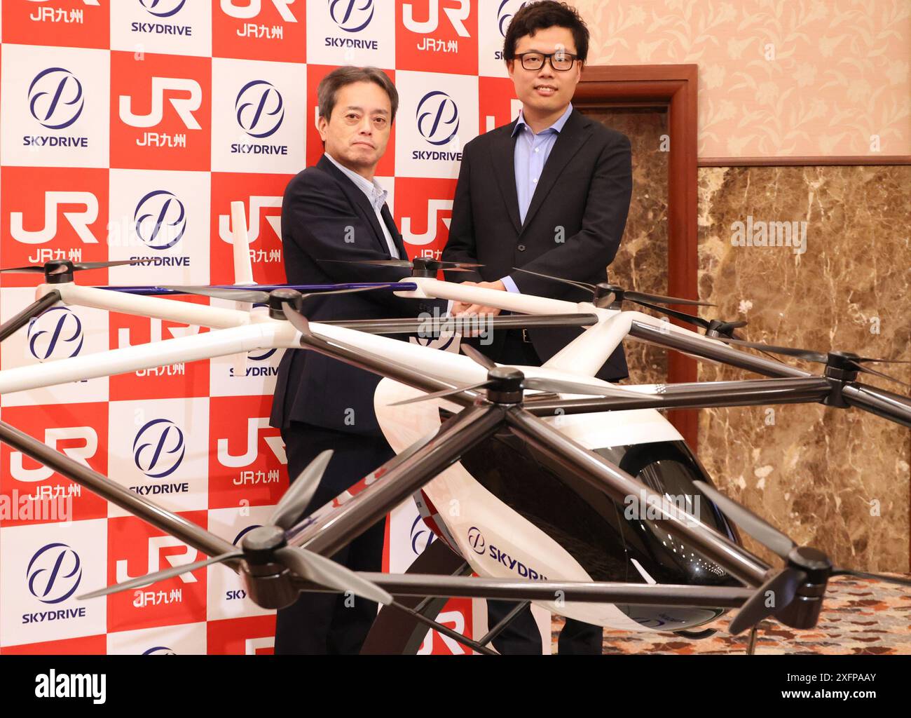Tokyo, Giappone. 4 luglio 2024. Il presidente giapponese di SkyDrive Tomohiro Fukuzawa (R) e il presidente della compagnia ferroviaria Kyushu (JR Kyushu) Yoji Furumiya (L) si pongono per una foto, in quanto hanno accettato di avviare uno studio di fattibilità per sviluppare eVTOL nella resione di Kyushu, Giappone occidentale, in una conferenza stampa congiunta tenutasi a Tokyo giovedì, 4 luglio 2024. SkyDrive ha iniziato a produrre l'ultima eVTOL SD-05 con Suzuki Motor e la presenterà al World Expo Osaka/Kansai il prossimo anno. (Foto di Yoshio Tsunoda/AFLO) Foto Stock