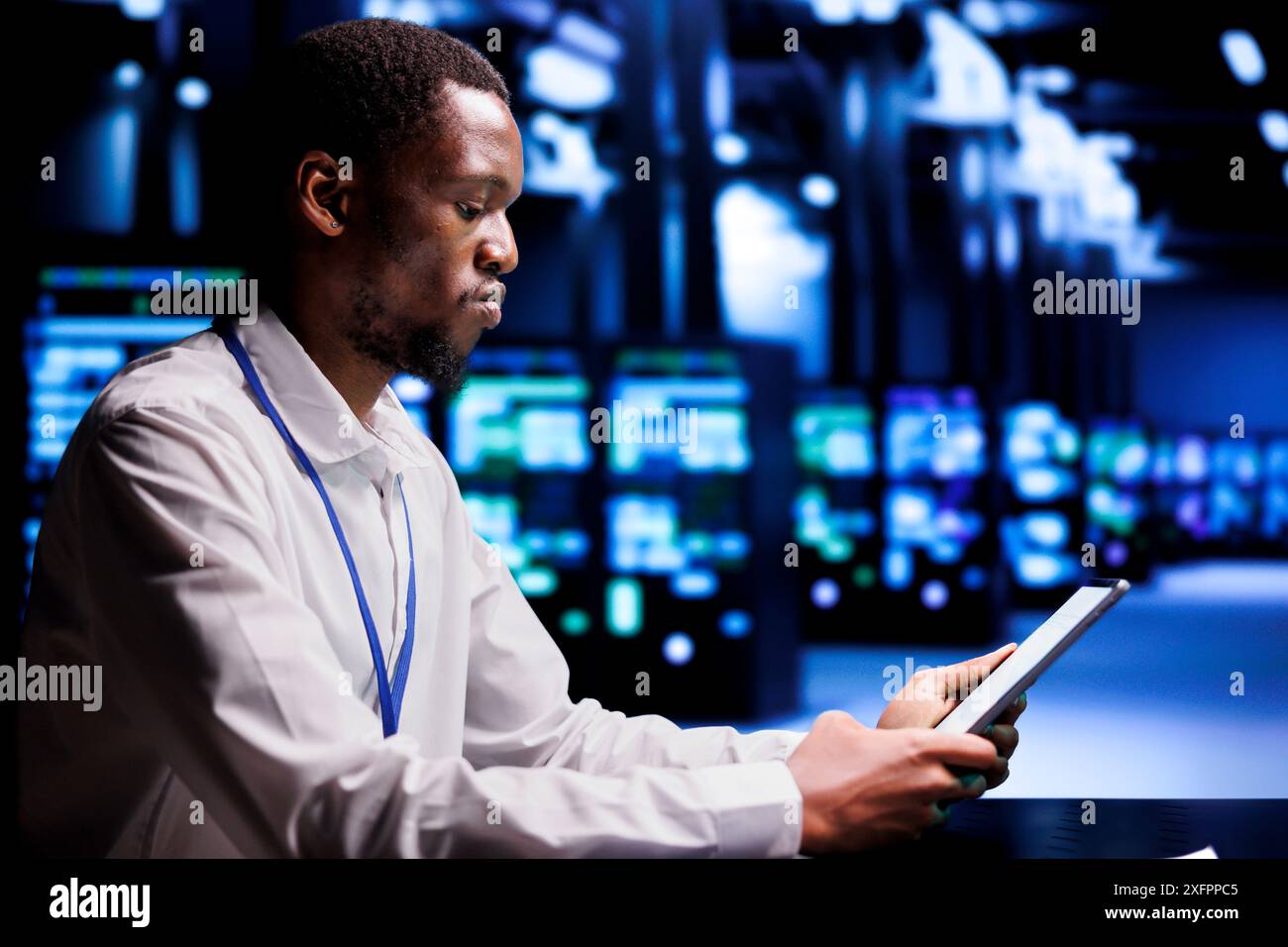 Responsabile del supporto tecnico che risolve i problemi relativi alle prestazioni nei mainframe dei data center. Manager che utilizza un tablet simulato per identificare i problemi operativi che causano il rallentamento dell'hardware Foto Stock