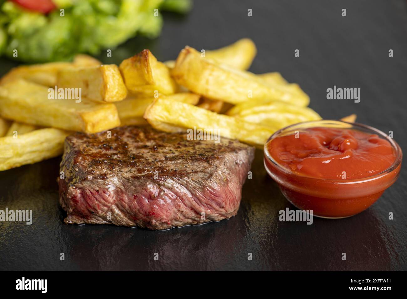 Bistecca con patatine fritte sull'ardesia Foto Stock