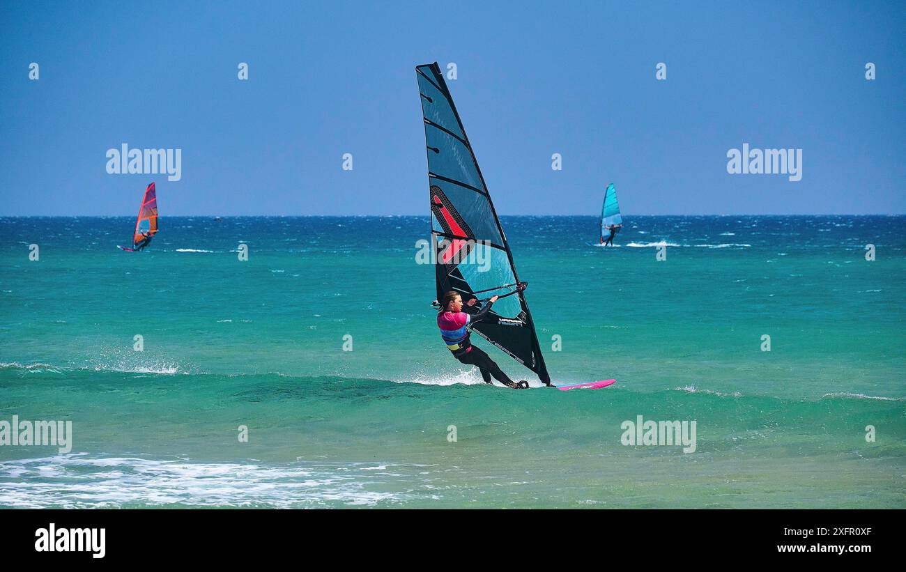 Diversi windsurfer navigano l'acqua blu sotto un cielo limpido, il paradiso dei surfisti, kitesurfer, windsurf, Prasonisi, isola a sud di Rodi Foto Stock