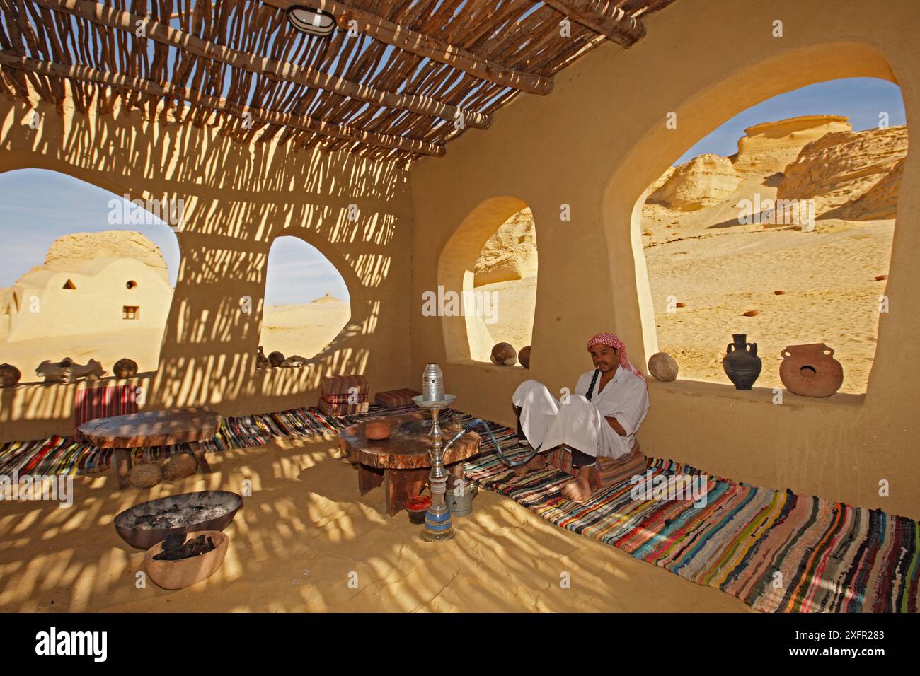 Uomo che fuma narghilè, Wadi El Hitan (Valle delle balene) Parco Nazionale Wadi Hitan, sito Patrimonio dell'Umanità dell'UNESCO, Egitto. Novembre 2008. Foto Stock