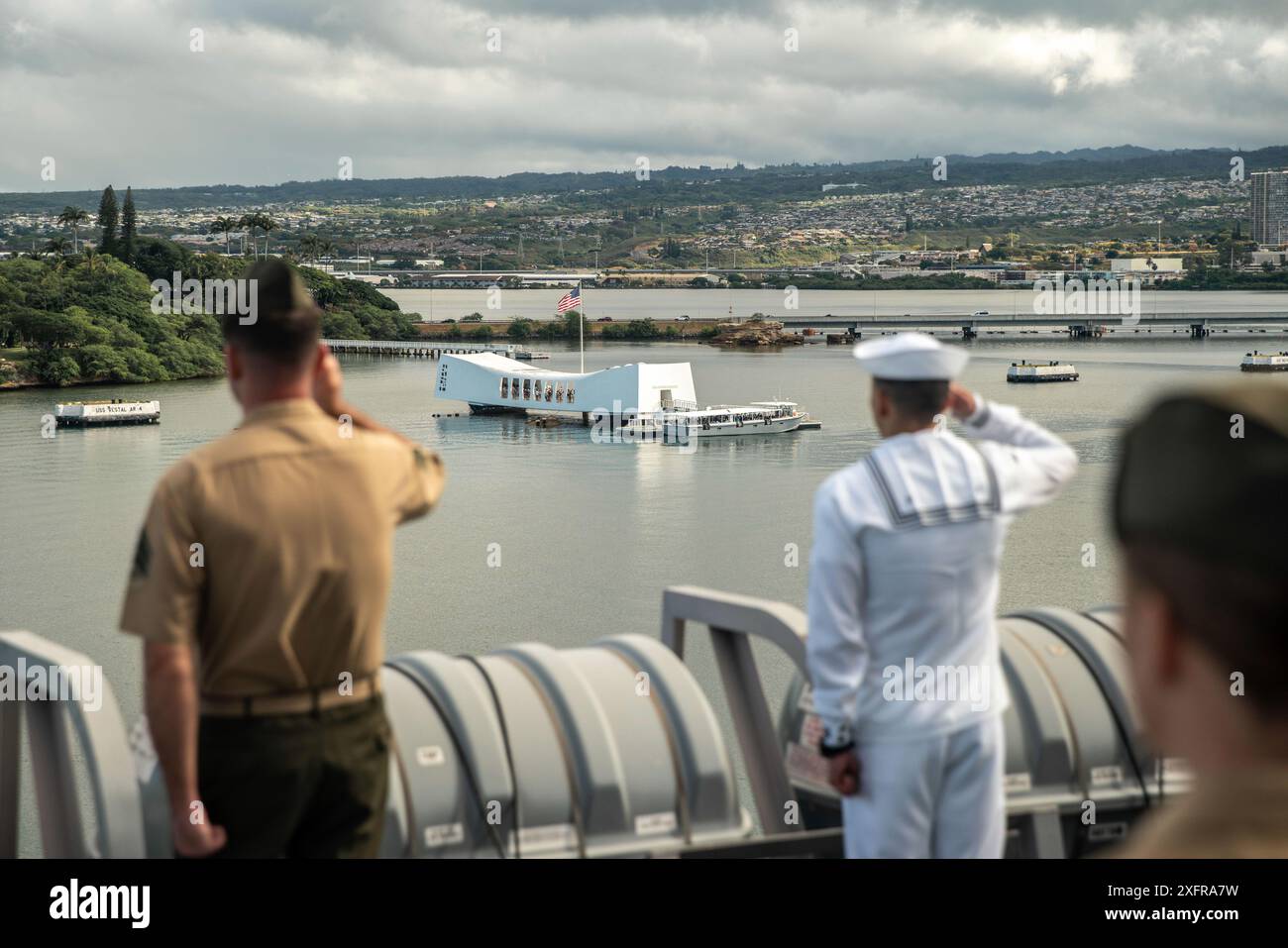 I marines statunitensi assegnati alla 15th Marine Expeditionary Unit e i marinai assegnati al molo di trasporto anfibio USS Somerset (LPD 25) salutano lo USS Arizona Memorial mentre maneggiano le rotaie mentre Somerset si tira in porto per l'Exercise Rim of the Pacific 2024 presso Joint base Pearl Harbor-Hickam, Oahu, Hawaii, 3 luglio 2024. Ventinove nazioni, 40 navi di superficie, tre sottomarini, 14 forze terrestri nazionali, più di 150 aerei e 25.000 personale partecipano al RIMPAC nelle e intorno alle isole Hawaii, dal giugno 27 al agosto 1. Il RIMPAC, il più grande esercizio marittimo internazionale al mondo, offre un Foto Stock