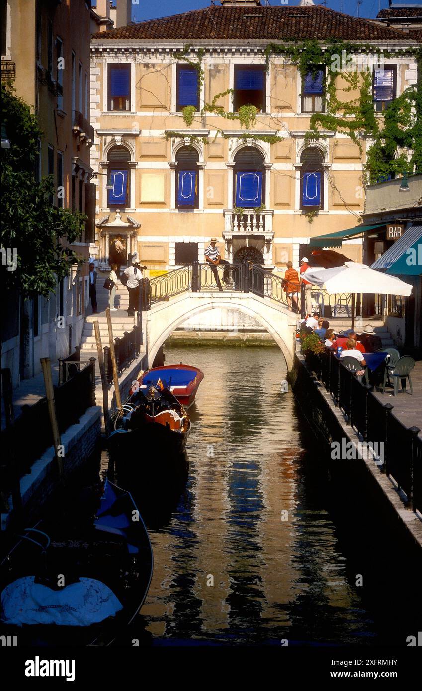 Gondoliere sul ponte sul canale, Venezia, Italia Foto Stock