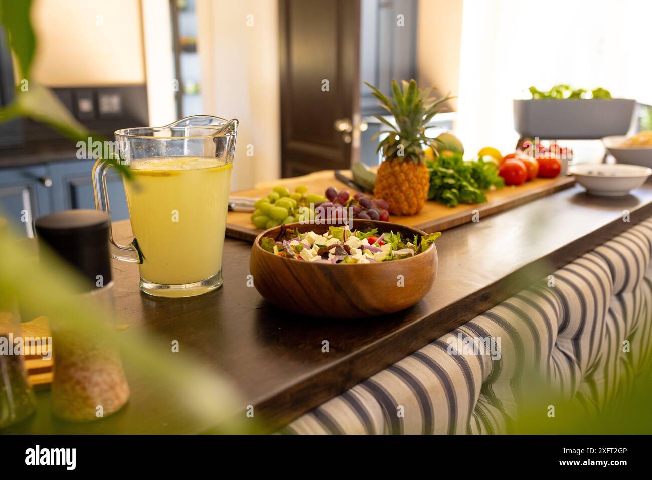 Insalata fresca e limonata sul bancone della cucina con frutta e verdura Foto Stock