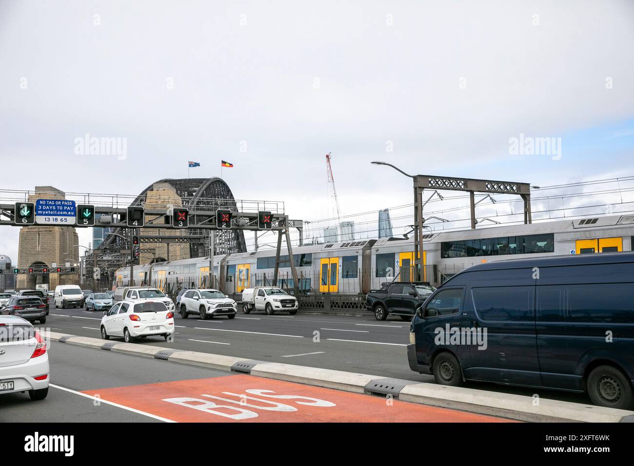 Traffico di Sydney sulla Bradfield Highway che attraversa il ponte del porto di Sydney, con il treno di Sydney che corre lungo i binari, NSW, Australia Foto Stock