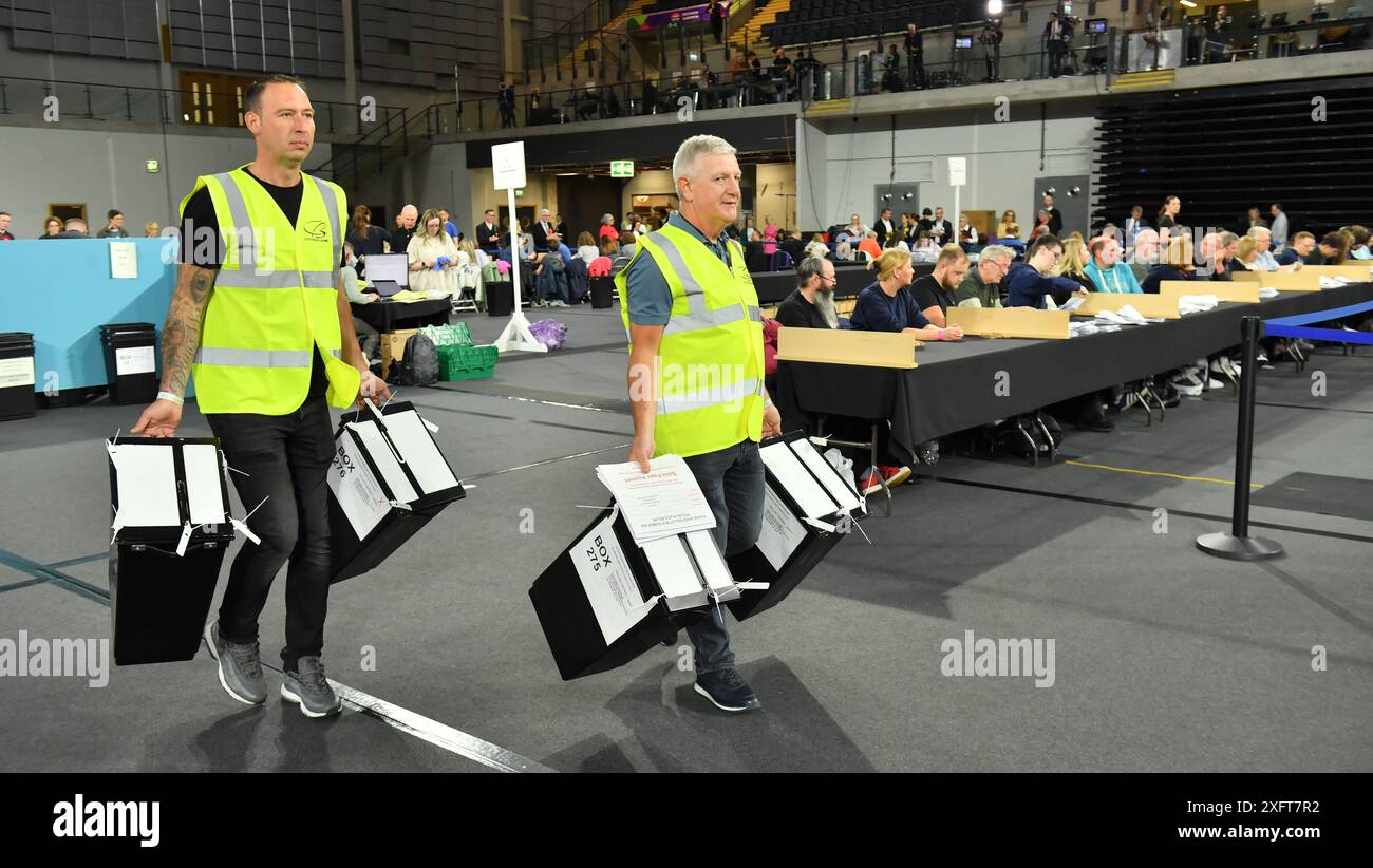 Glasgow, Regno Unito. 5 luglio 2024. NELLA FOTO: Le urne arrivano nell'arena dei conteggi elettorali. Scene dall'interno del Glasgow Election Count all'Emirates Arena (Sir Chris Hoy Velodrome) alla vigilia finale delle elezioni generali del Parlamento britannico del 2024, con le urne caricate e contate e i candidati del partito che guardano e contano. Foto di Colin D Fisher. Crediti: Colin Fisher/Alamy Live News Foto Stock