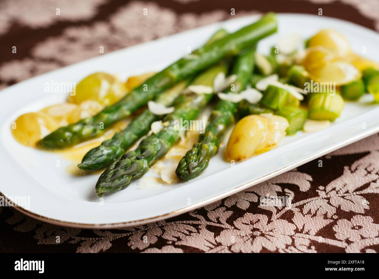 Asparagi verdi con uve saltate e salsa di vino bianco Foto Stock