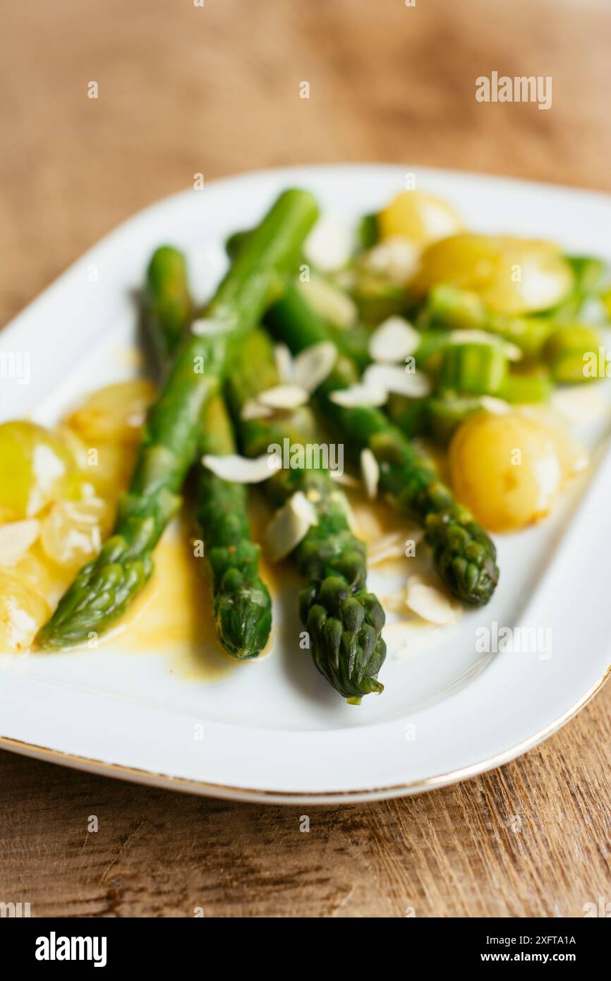 Asparagi verdi con uve saltate e salsa di vino bianco Foto Stock