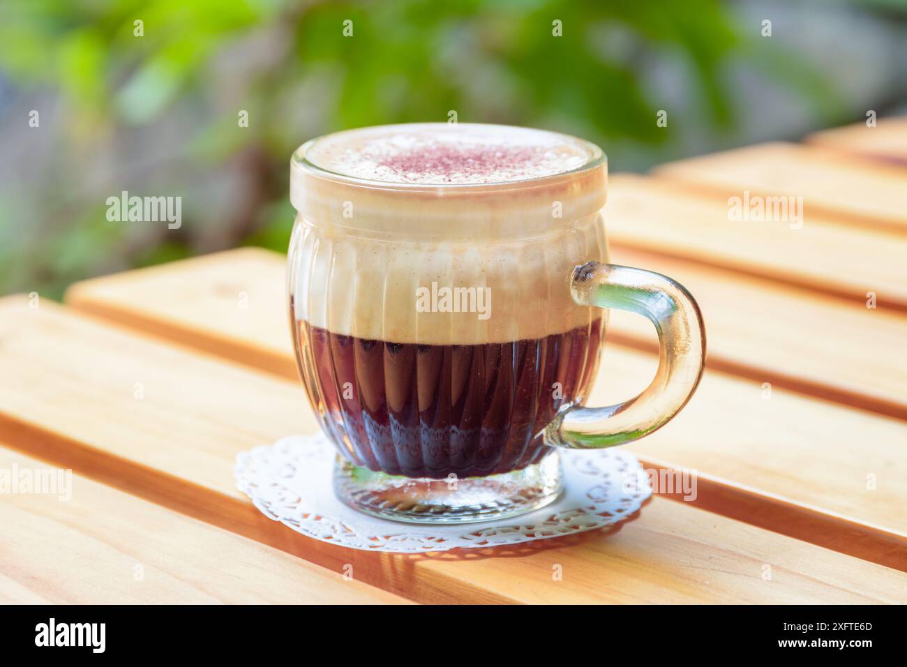 Vista dall'alto di una tazza di caffe' vietnamita all'uovo (CA phe trung) sul tavolo di legno del caffe' in strada. Bevanda tradizionale in Vietnam. Foto Stock