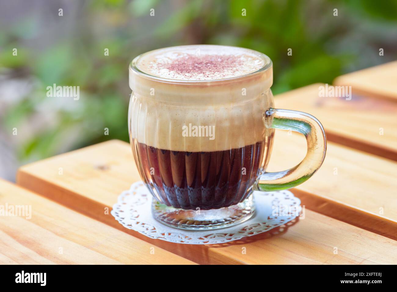 Vista dall'alto di una tazza di caffe' vietnamita all'uovo (CA phe trung) sul tavolo di legno del caffe' in strada. Bevanda tradizionale in Vietnam. Foto Stock