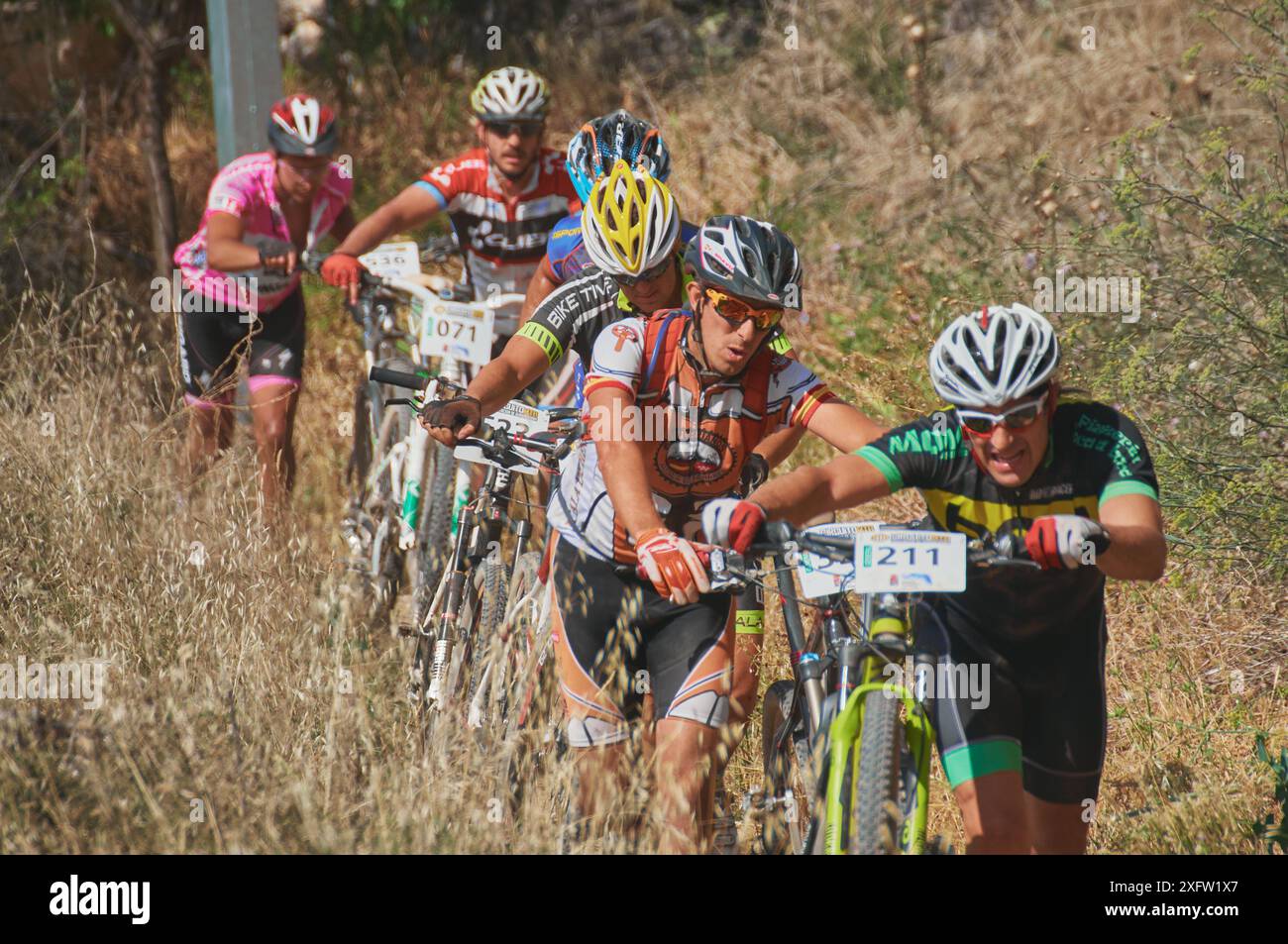 03-08-2014 Brihuega, Spagna - i ciclisti spingono le bici in salita in una gara di MTB calda e asciutta nella regione di Brihuega in Alcarria Foto Stock