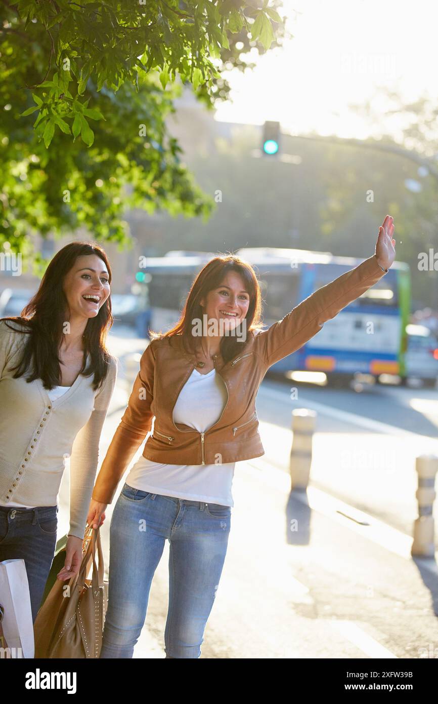 Le donne sorelle 35 e 40 anni salutando una cabina. Lo shopping sulla strada. Donostia. San Sebastian. Gipuzkoa. Paese basco. Spagna. Foto Stock