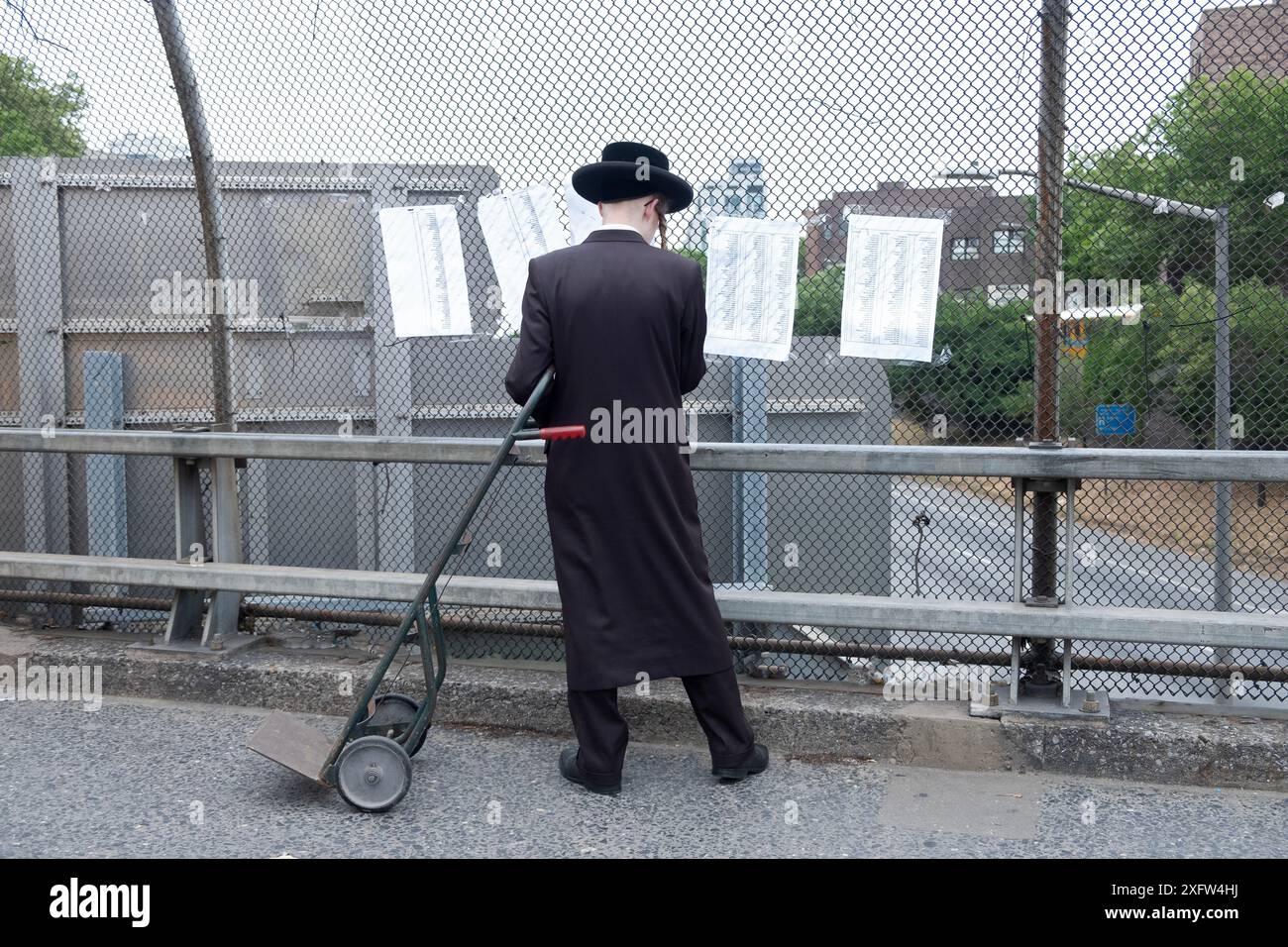 Dopo aver caricato gli effetti personali dei suoi fratelli su un camion al campo estivo, un chassidico controlla una lista per assicurarsi che siano sul camion corretto NYC. Foto Stock