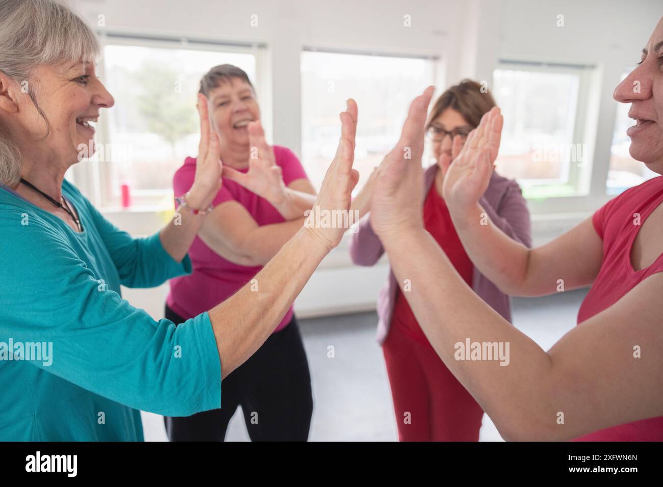 Donne allegre che si danno cinque alte l'una all'altra in studio di danza Foto Stock