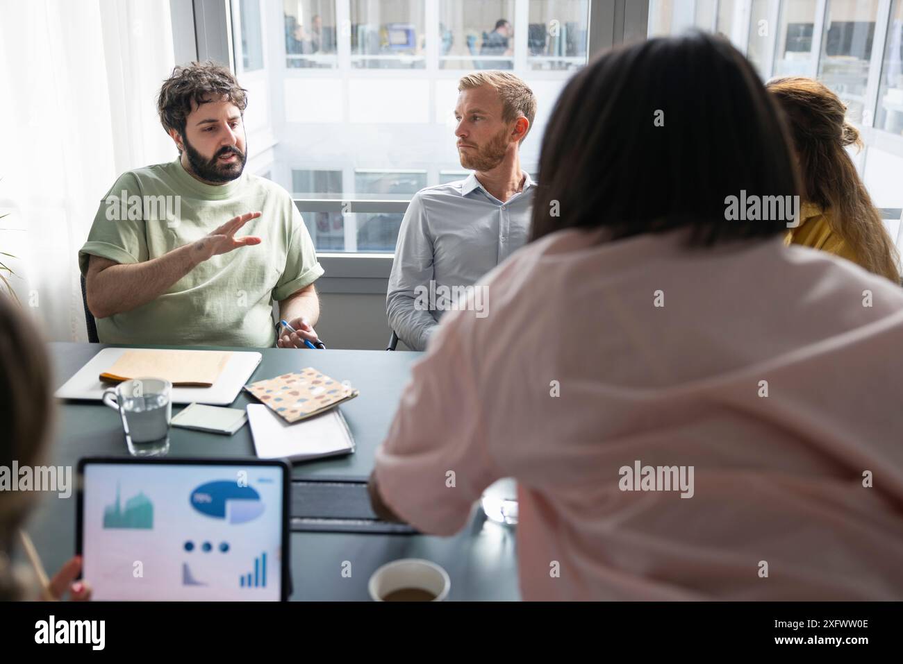 Uomo d'affari che discute nuove idee con i colleghi in ufficio Foto Stock