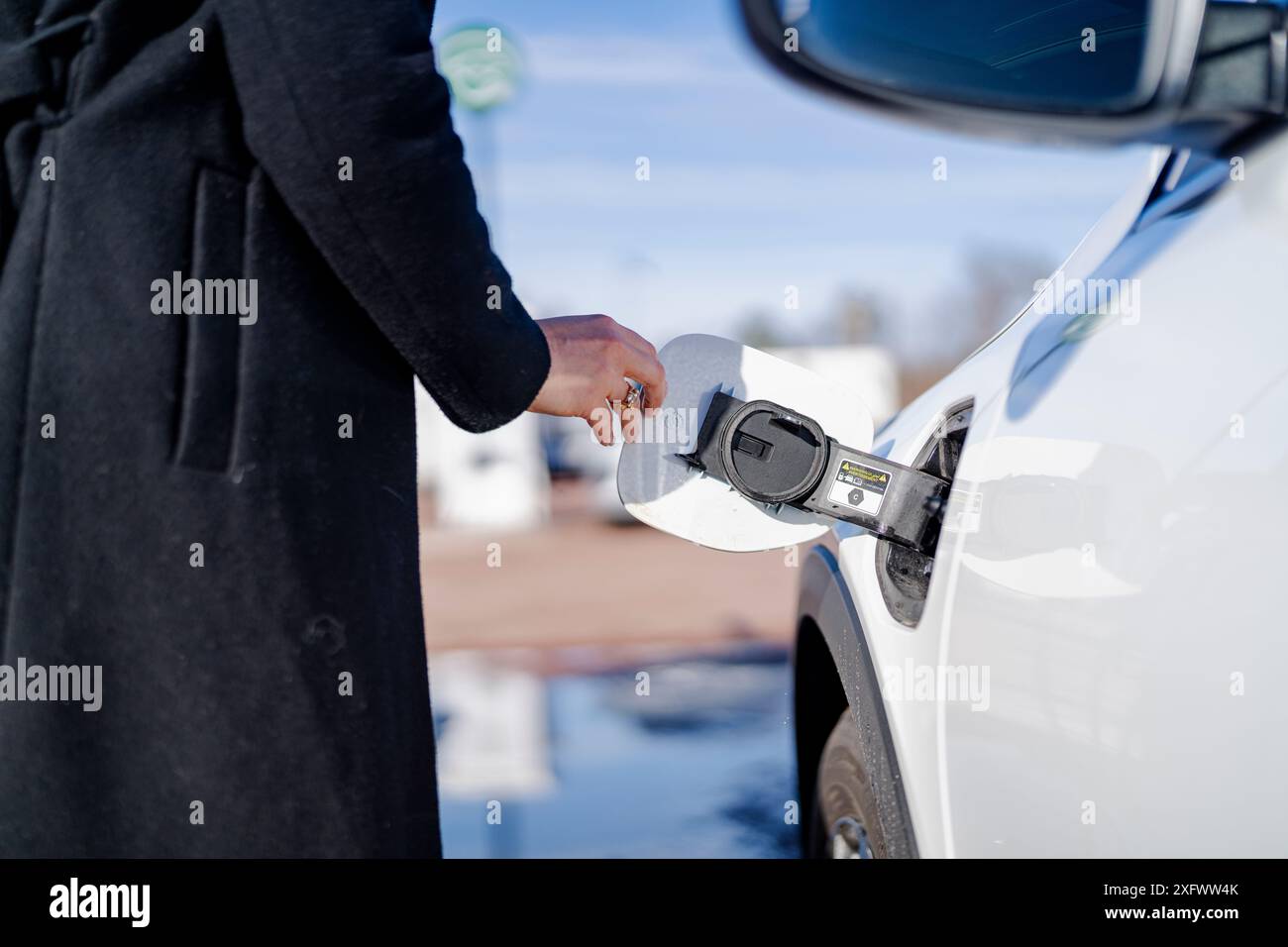 Mano di donna che apre il tappo del serbatoio carburante Foto Stock