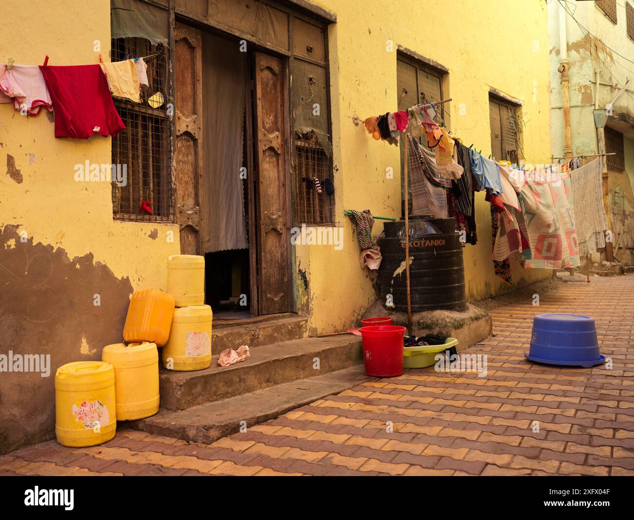Una casa nelle strade di Mombasa in Kenya con lavanderia appesa ad asciugare entrambi i lati della porta d'ingresso Foto Stock