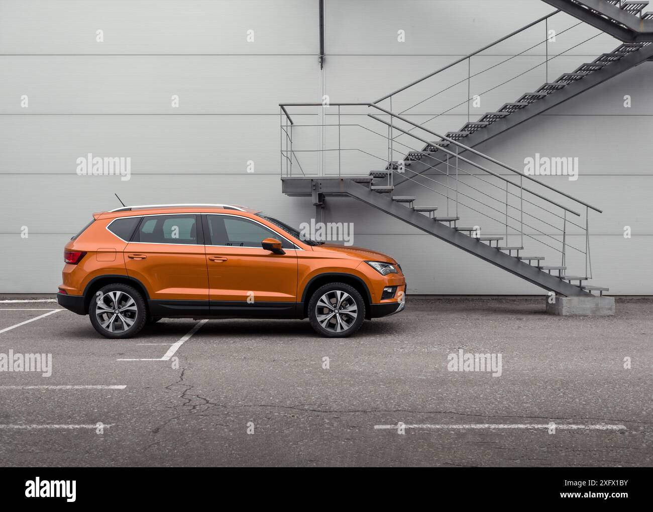 Samoa Orange SEAT Ateca crossover davanti al muro grigio. Vista laterale del suv compatto. Foto Stock