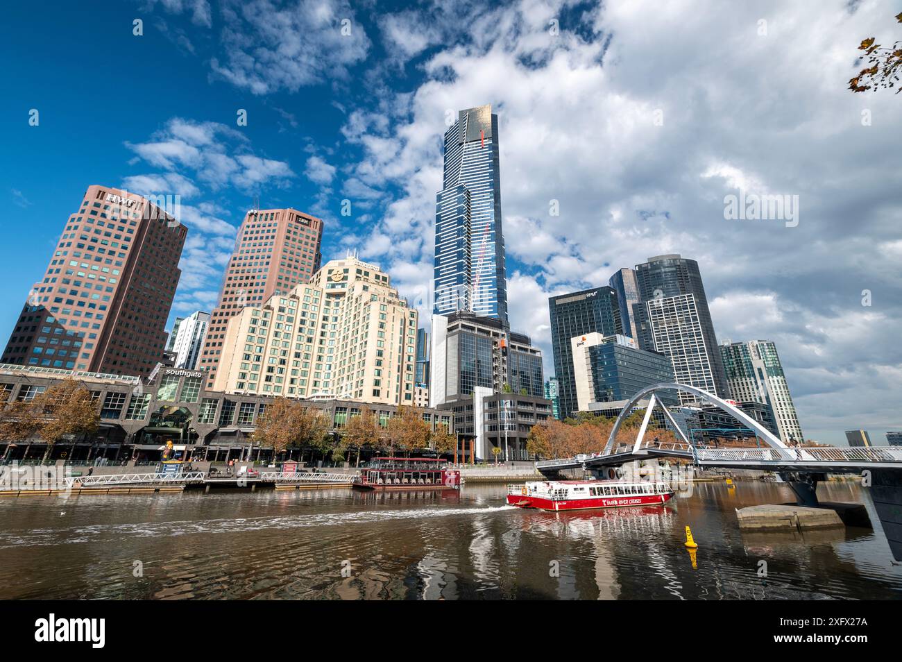 Lo skyline di Southbank sul fiume Yarra prende il nome dalla parola aborigena che significa "fiume fluente", a Melbourne, Victoria, Australia. Il piccolo ponte, il centro benessere Foto Stock