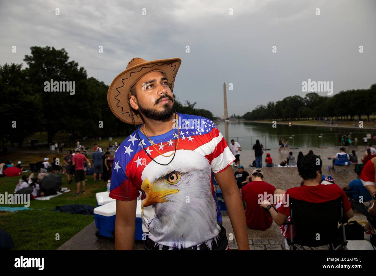 Washington DC, Stati Uniti. 4 luglio 2024. Tasfiq, un americano bengalese della Florida attende i fuochi d'artificio per celebrare il giorno dell'indipendenza degli Stati Uniti il 4 luglio 2024 a Washington DC. La capitale della nazione è stata decorata in rosso, bianco e blu giovedì mentre migliaia di persone si sono imbattute nel paese per festeggiare il 4 luglio. Crediti: SIPA USA/Alamy Live News Foto Stock