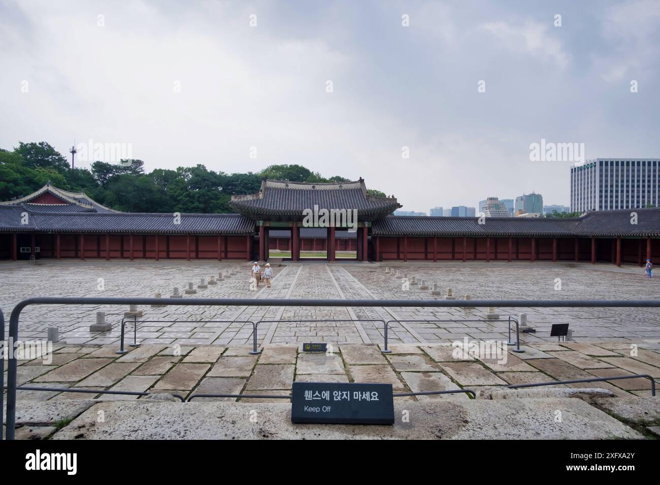 Palazzo Changdeokgung, Seoul (Corea del Sud). Tradizionale cortile del palazzo coreano con lo skyline moderno della città sullo sfondo, mescolando architettura vecchia e nuova Foto Stock