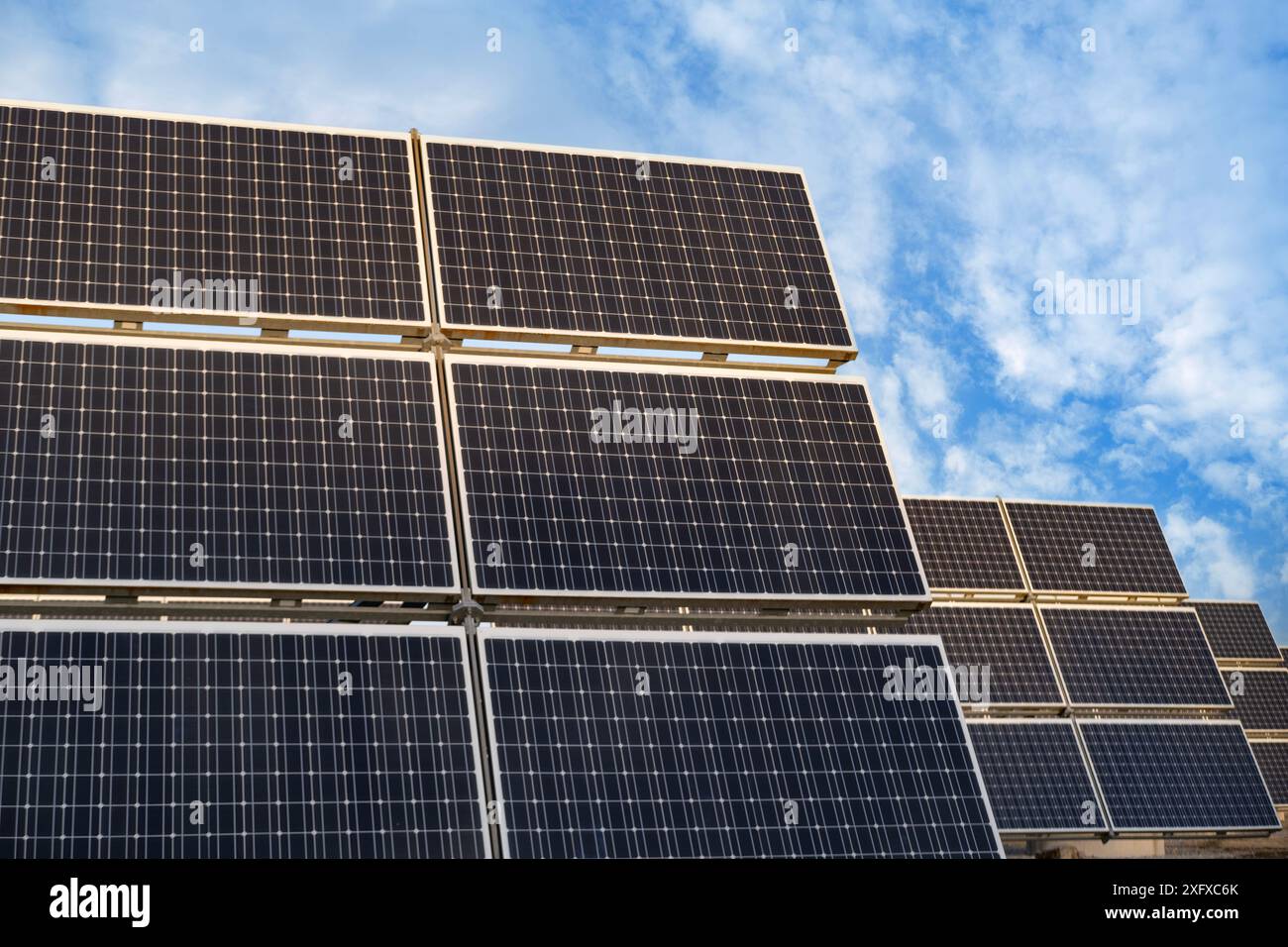 Le file di pannelli fotovoltaici si estendono attraverso le fattorie solari, catturando l'energia solare per un futuro sostenibile, l'energia pulita delle fattorie solari, generando elettricità fr Foto Stock