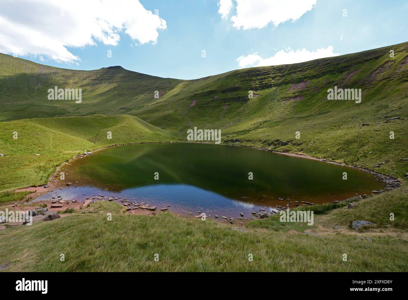 Lago glaciale Llyn Cwm Llwch e montagna Corn Du. Sito di interesse scientifico speciale (SSSI) e sito di revisione della conservazione geologica. Brecon Beacons National Park, Breconshire, Galles, Regno Unito. Luglio 2018. Foto Stock