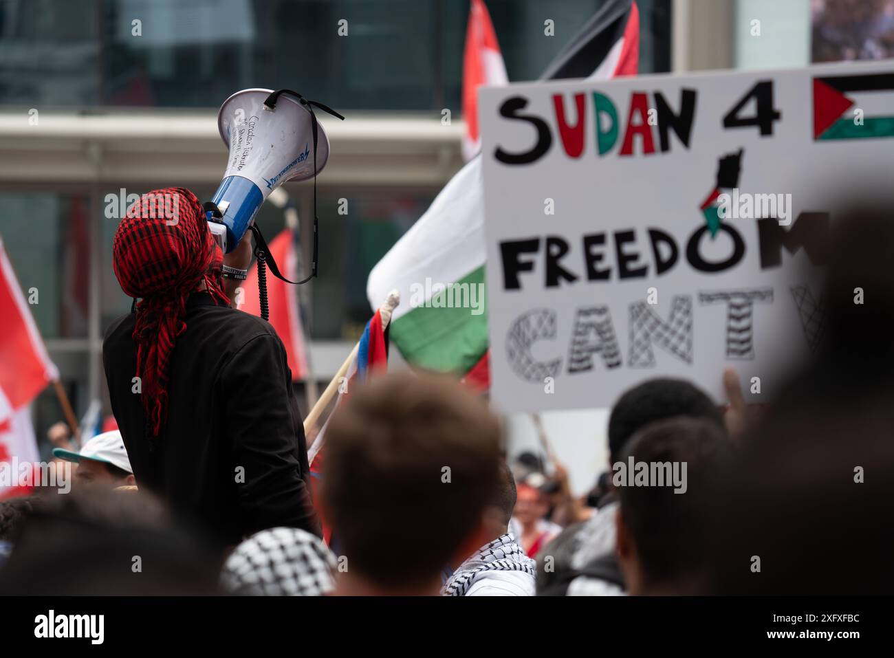 Manifestanti all'All Out for Gaza protesta che marciano, protestano e parlano alla folla per le strade di Toronto, Ontario Canada. Foto Stock