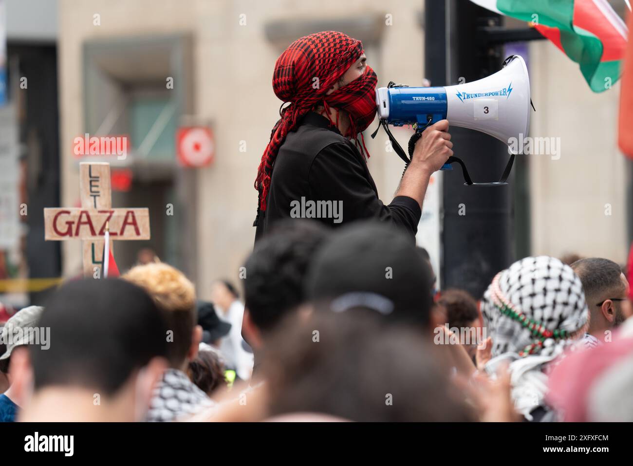 Manifestanti all'All Out for Gaza protesta che marciano, protestano e parlano alla folla per le strade di Toronto, Ontario Canada. Foto Stock