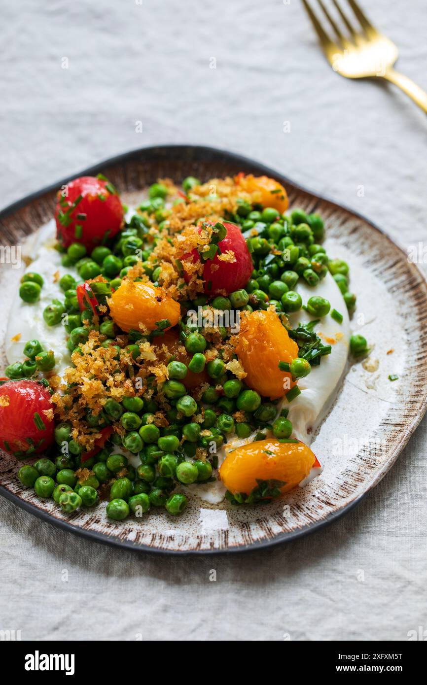 Burrata con piselli verdi grigliati, pomodori sottaceto e pangrattato Foto Stock