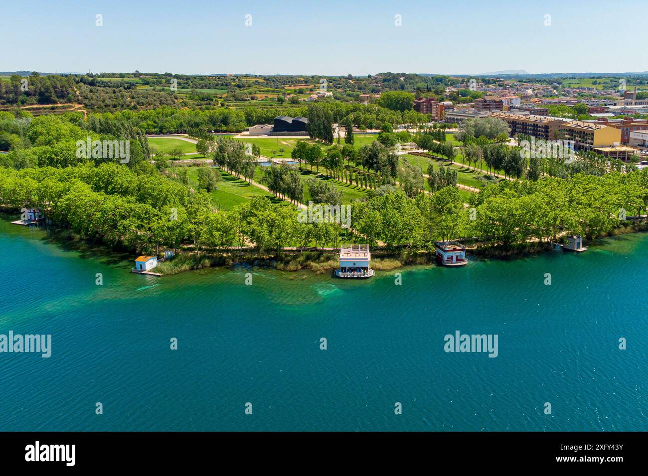 Vista aerea del lago Banyoles all'alba a Girona, Catalogna, Spagna. Ripresa in droni di un tranquillo paesaggio lacustre al mattino con luce calda al tramonto Foto Stock