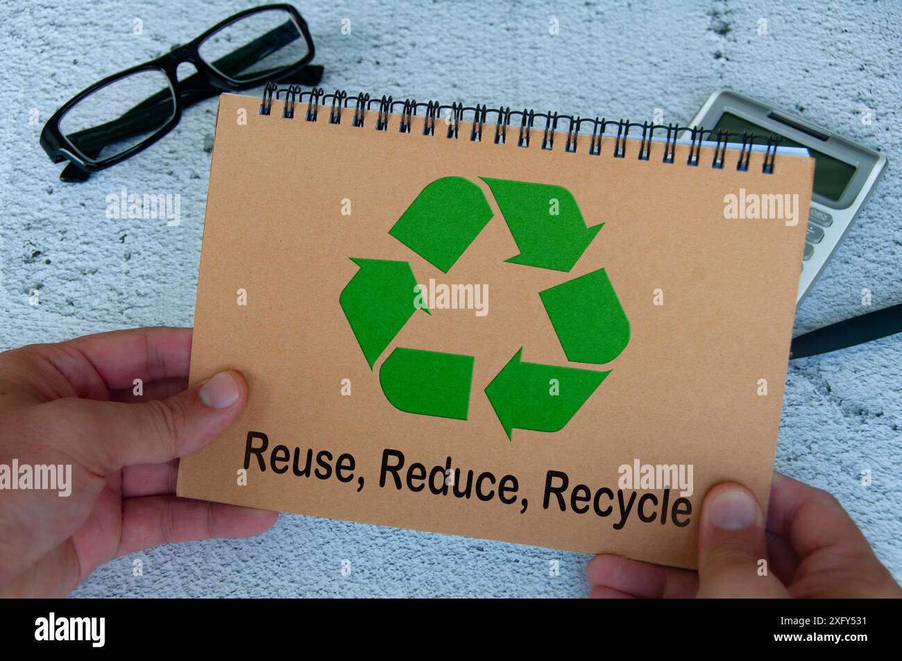 Simbolo di riciclaggio sul notebook marrone. Riutilizzare, ridurre e riciclare. Foto Stock