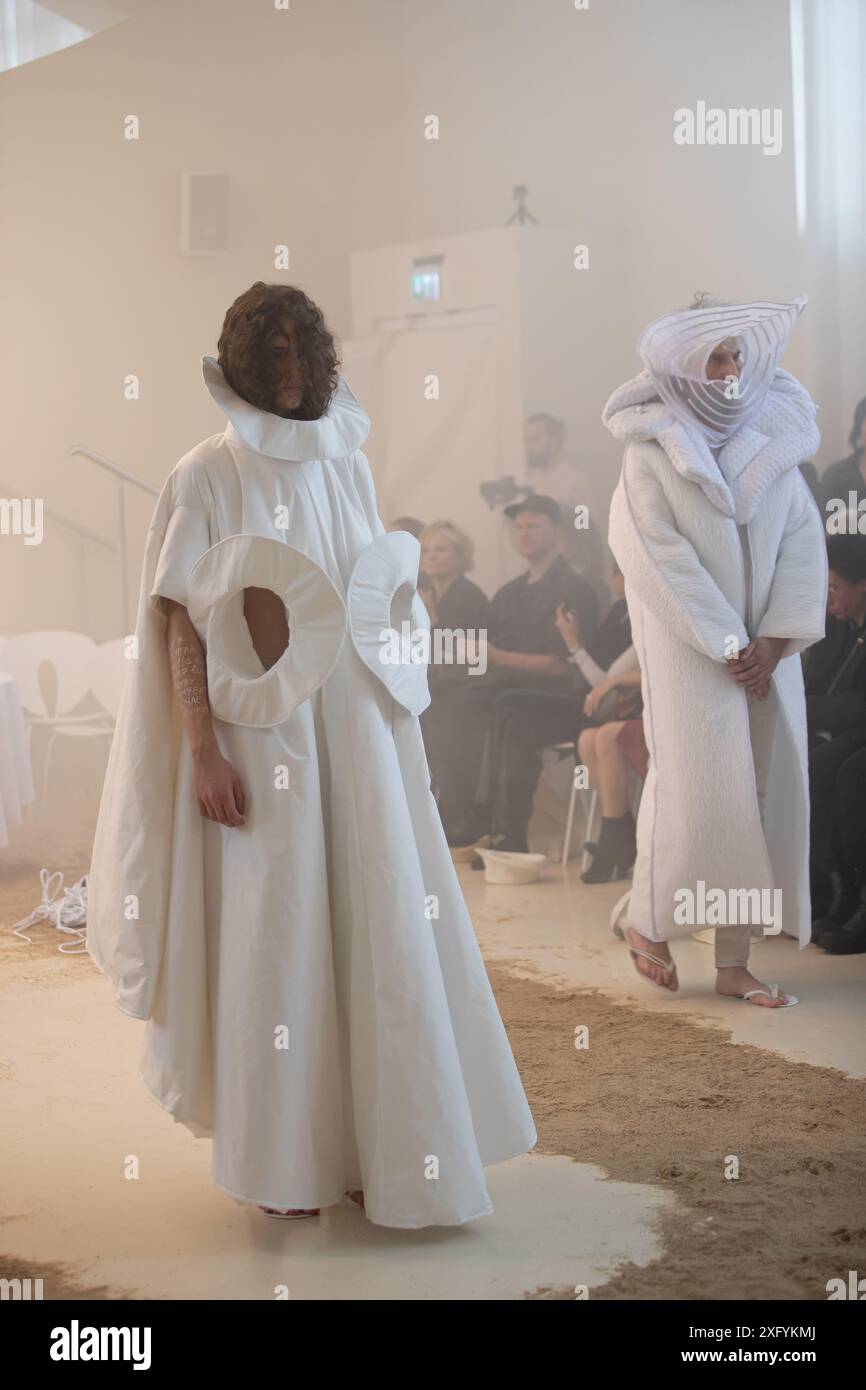 Berlino, Germania, 5 luglio 2026. Modello in tessuto bianco avant-garde con volant e aperture circolari alla sfilata DZHUS durante la Berlin Fashion Week. Foto Stock