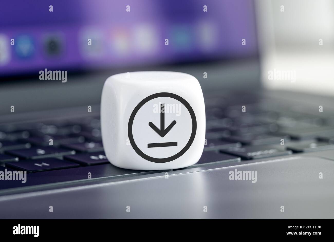 Scarica il concetto di archiviazione dei dati. Icona di download sul blocco cubo sul notebook Foto Stock