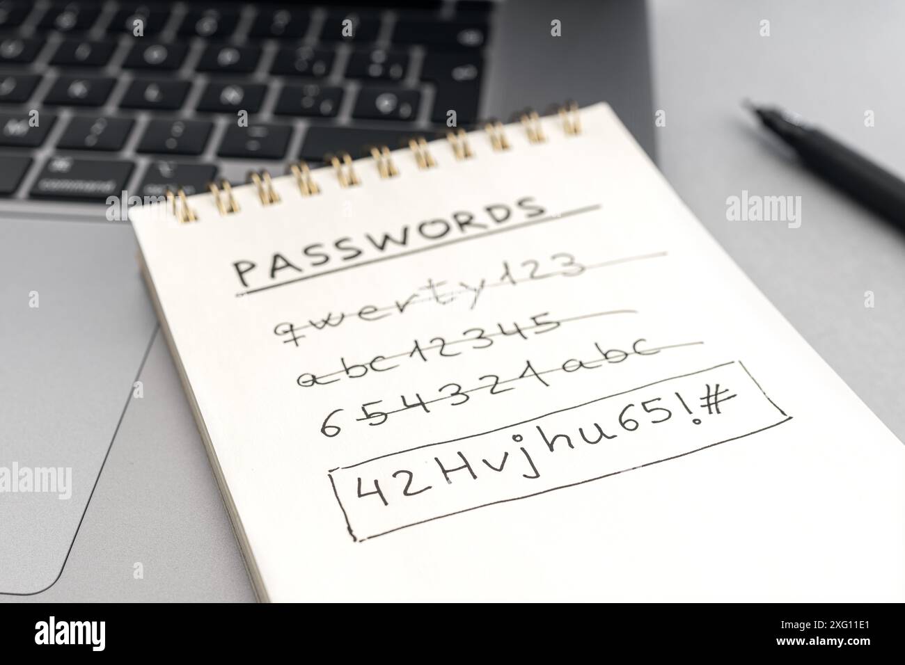 Concetto di password di protezione avanzata del computer. Modifica di una password facile debole per una password sicura. Testo scritto a mano sul blocco note sul computer portatile Foto Stock