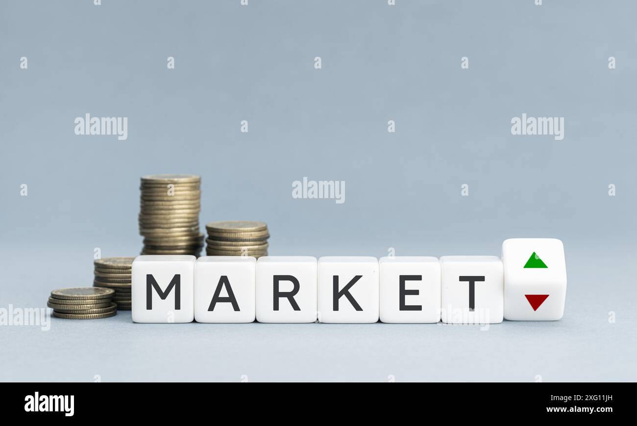 Parola di mercato e frecce su e giù sulla forma del blocco e monete impilate. Spazio di copia Foto Stock