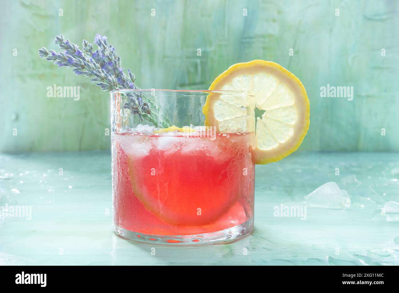 Cocktail estivo o mocktail, una bevanda fredda con limone e lavanda, limonata da festa su sfondo blu Foto Stock