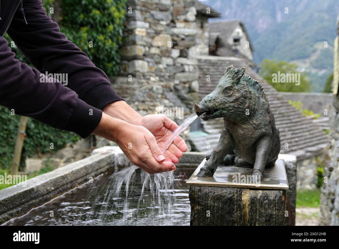 Lavare le mani in un pozzo vecchio con acqua fresca - lavare le mani in un pozzo vecchio con acqua fresca Foto Stock