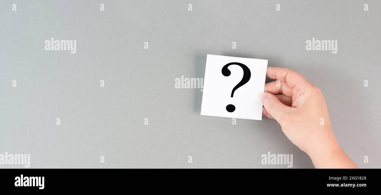 Punto interrogativo in mano, alla ricerca di una risposta, alla ricerca di conoscenze, alla risoluzione dei problemi, al concetto di business e di istruzione Foto Stock