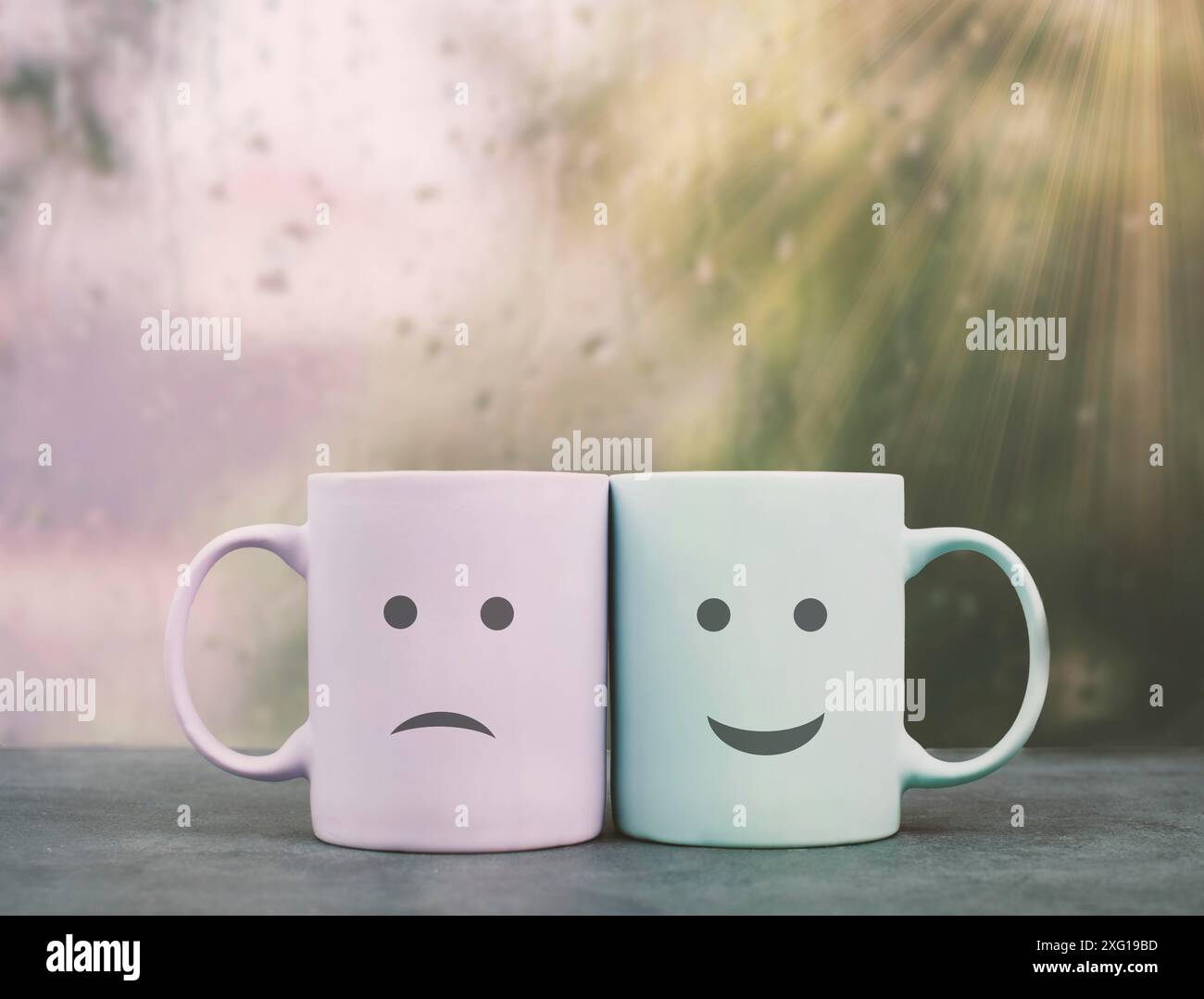 Faccia felice e triste, coppia della tazza su una sporgenza della finestra si coccola l'un l'altro, bevanda calda su un giorno piovoso, amore, rapporto e concetto di amicizia Foto Stock