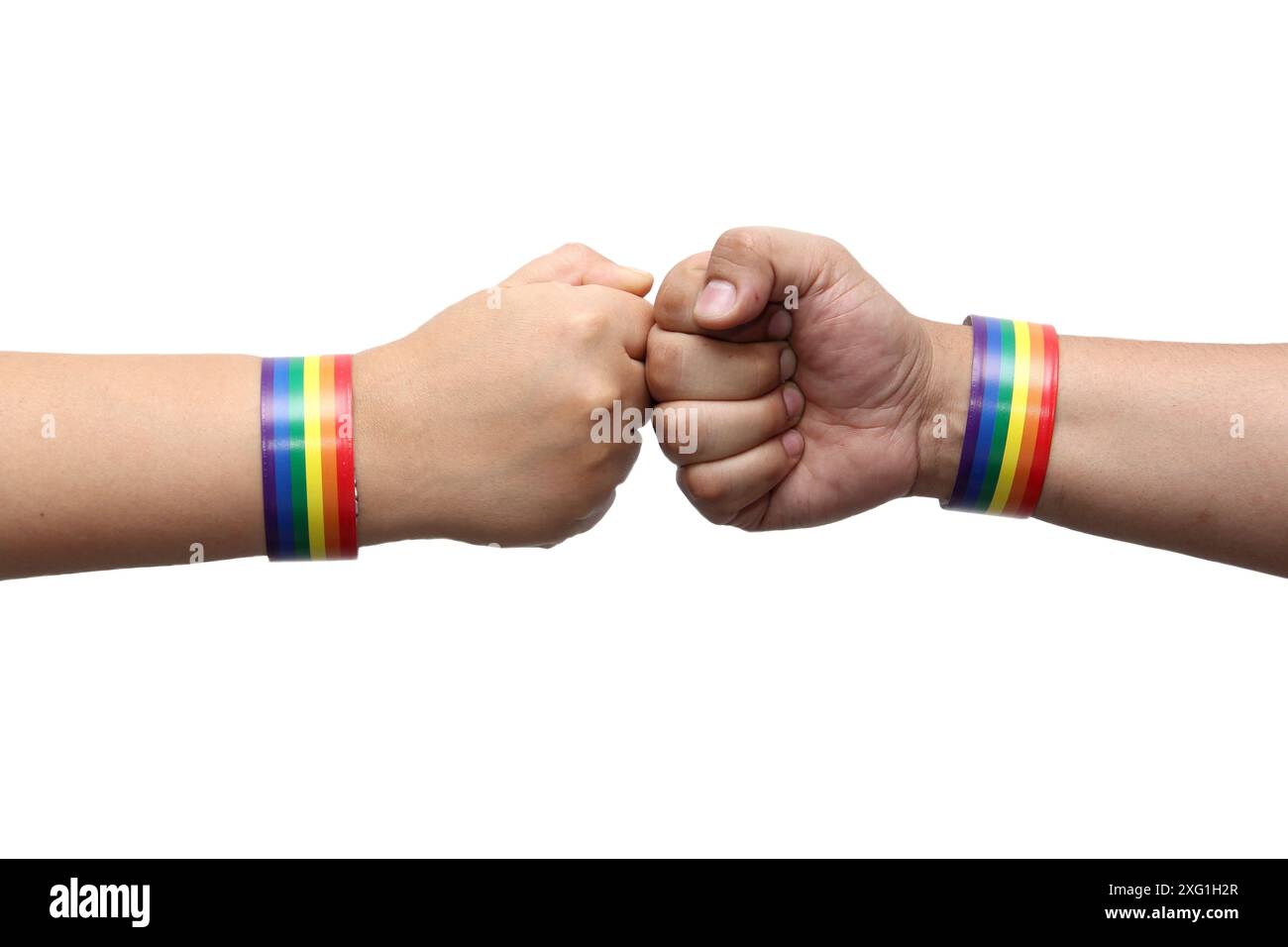 Due mani di 2 persone con braccialetti con i colori arcobaleno della bandiera gay, un simbolo che rappresenta la comunità LGBTQIA+, sono mostrate con orgoglio Foto Stock