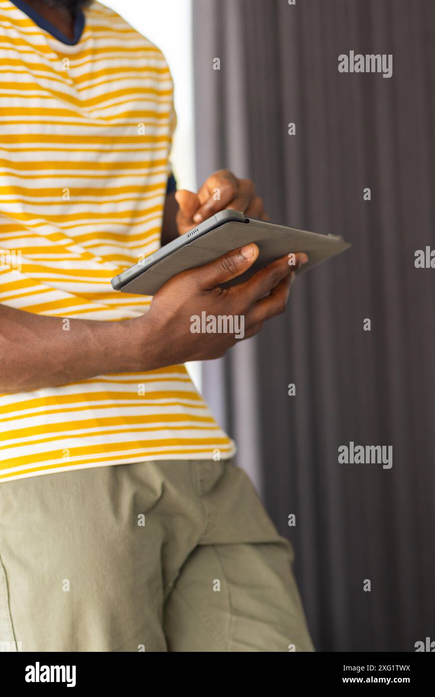 Con un tablet, uomo in un abbigliamento casual che si rilassa a casa Foto Stock
