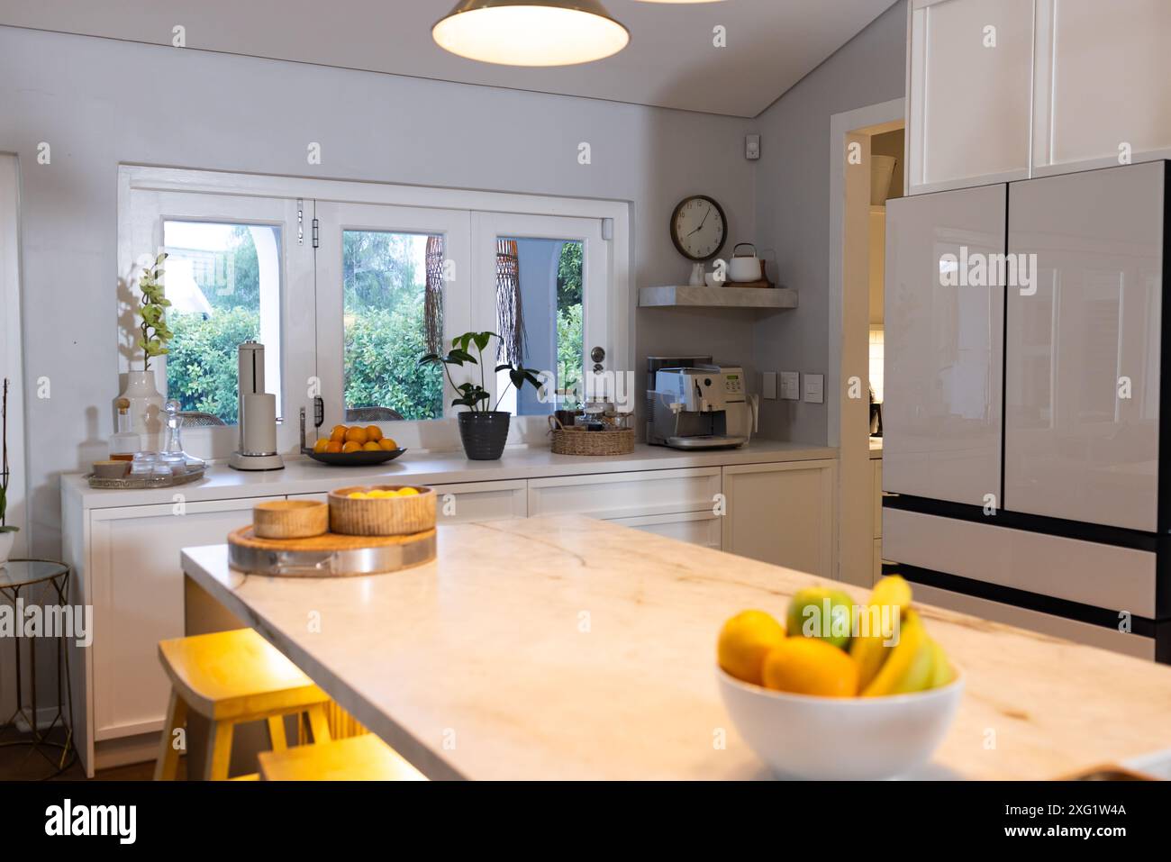 Cucina moderna con ripiano in marmo, cesto di frutta, macchina per il caffè sul banco e spazio per fotocopie Foto Stock