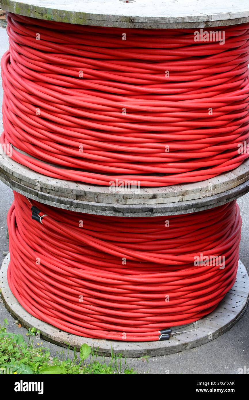 Bobine per cavi elettrici rossi isolati ad alta tensione nel magazzino dell'azienda elettrica Foto Stock
