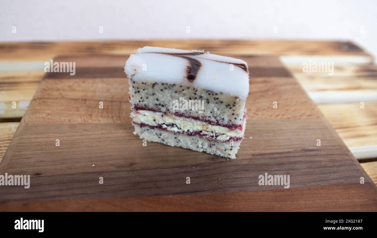 Torta a strati con spugne di semi papavero con ripieno di marmellata e panna e glassa di zucchero Foto Stock