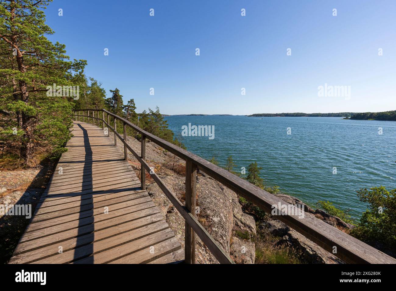 Passerella in legno sopraelevata sulla scogliera del Mar Baltico a Mariehamn, Isole Åland, Finlandia, in una giornata di sole in estate. Foto Stock