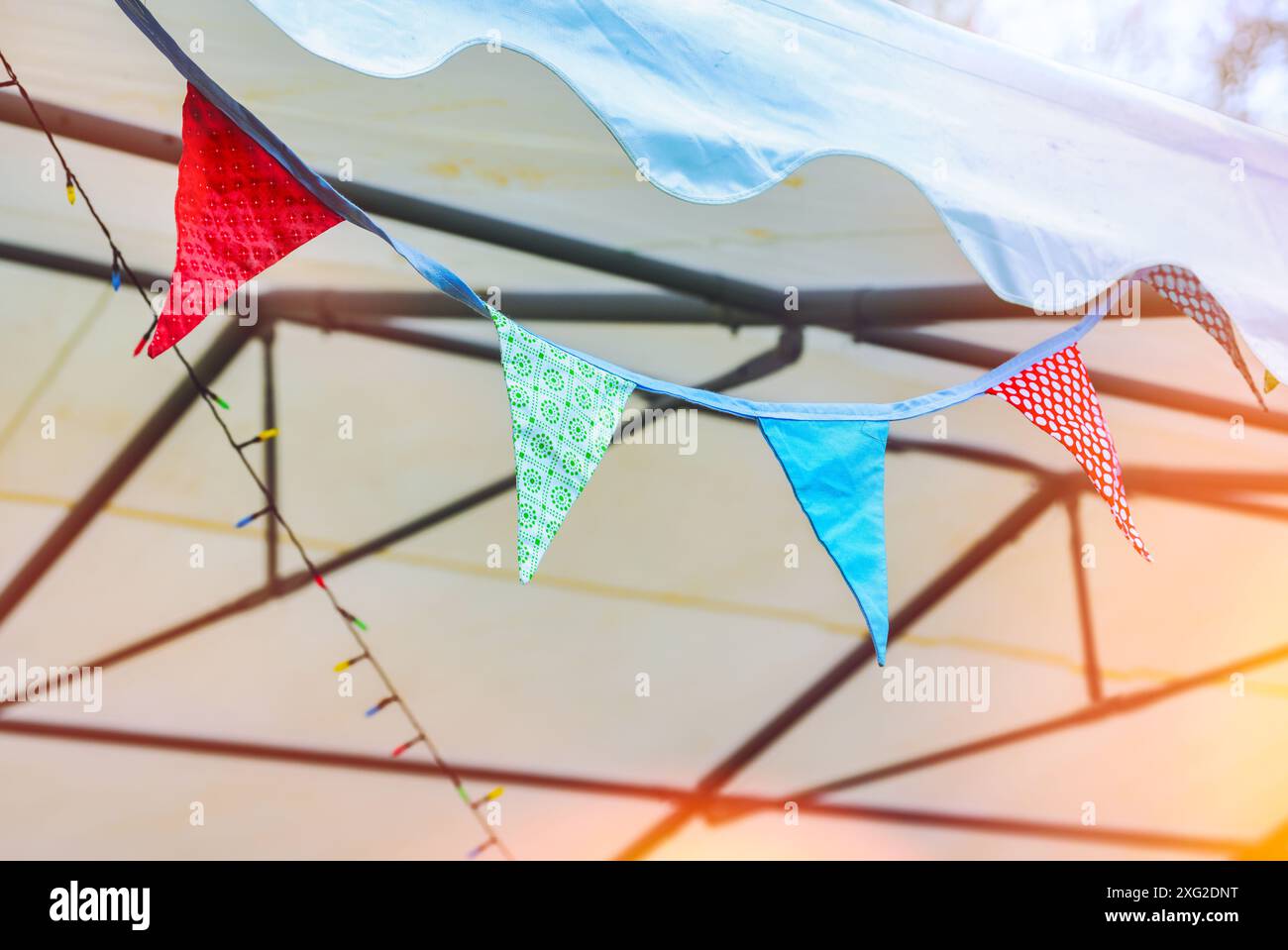 Ghirlanda di pennant colorati su una tenda di una festa in occasione di un festival estivo, spazio copia, messa a fuoco selezionata, profondità di campo ristretta Foto Stock