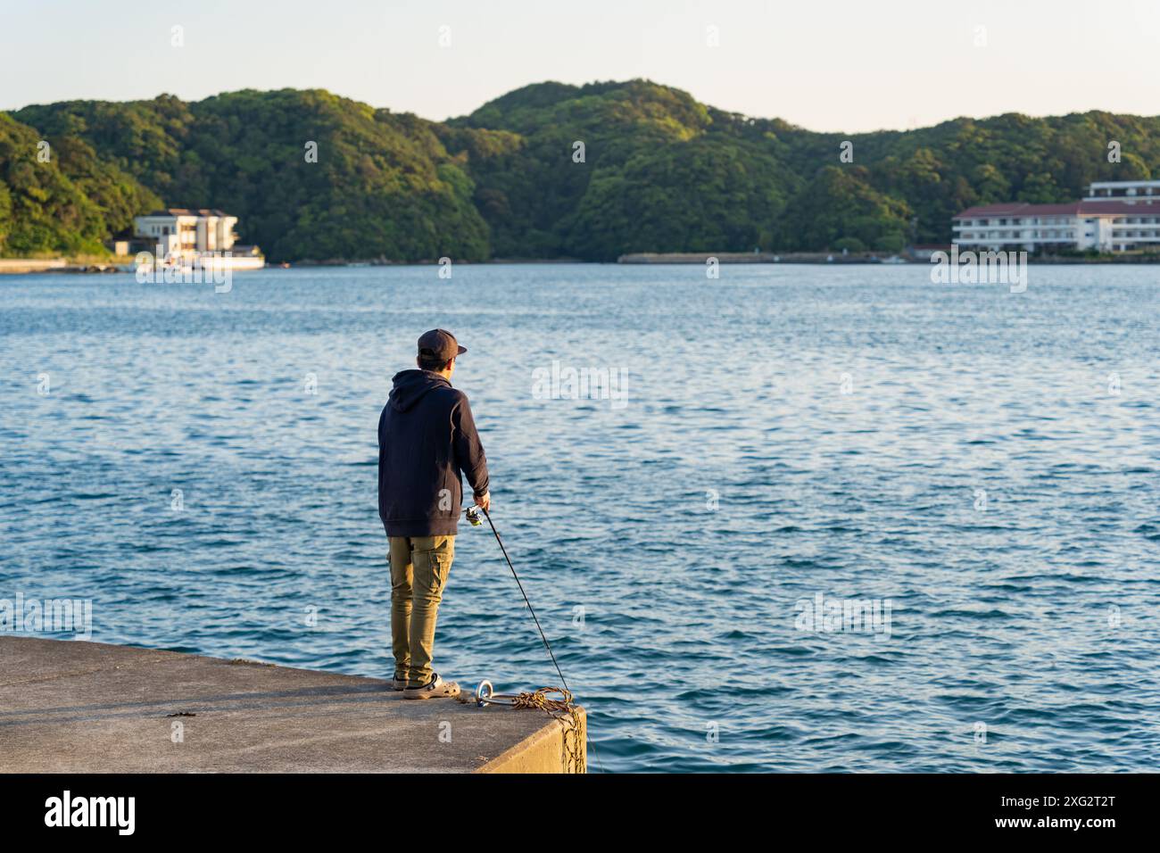Pescatore non identificabile che pesca dal tramonto del pierat a Katsuura, Wakayama, Giappone. Foto Stock