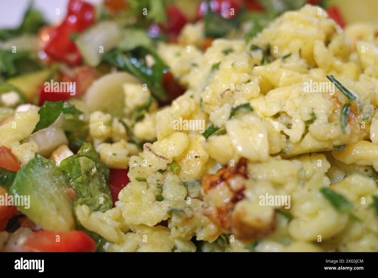 Uova strapazzate con erba cipollina tritata e verdure fritte in padella Foto Stock